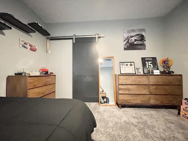 bedroom featuring a barn door and carpet floors