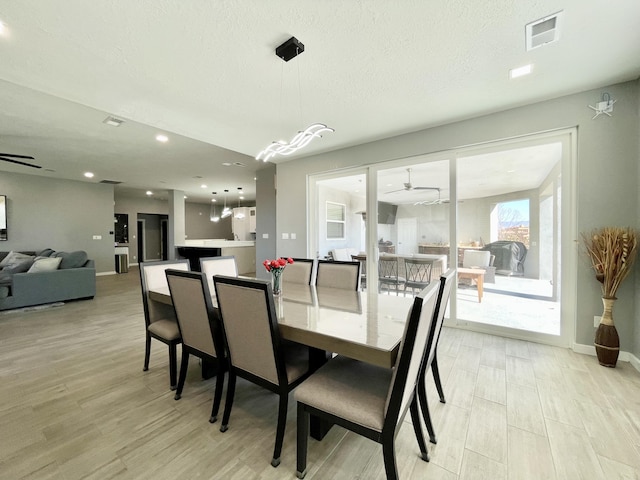 dining area with ceiling fan and a textured ceiling