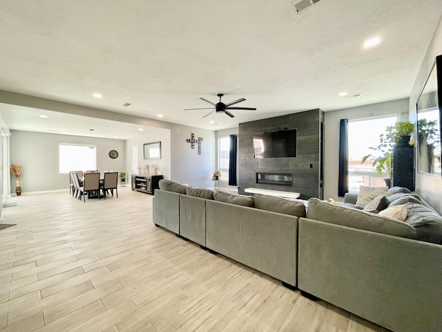 living room featuring a wealth of natural light, a textured ceiling, and light hardwood / wood-style flooring