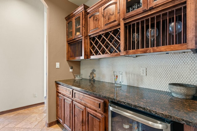 kitchen featuring wine cooler, tasteful backsplash, and dark stone countertops