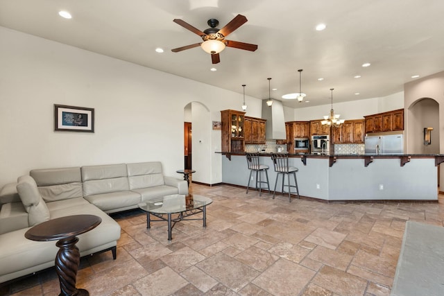 living room with ceiling fan with notable chandelier