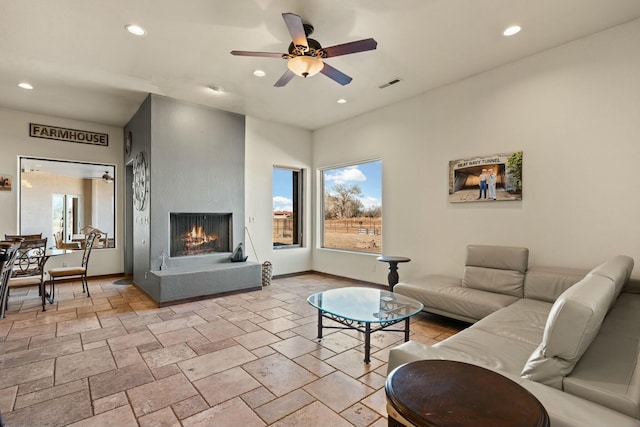 living room with a large fireplace and ceiling fan