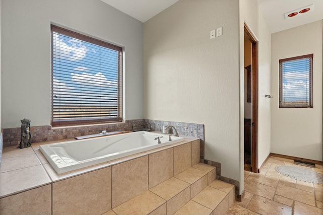 bathroom with plenty of natural light and tiled bath