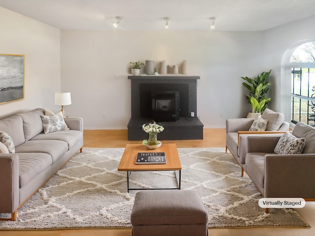 living room featuring a wood stove and light hardwood / wood-style flooring