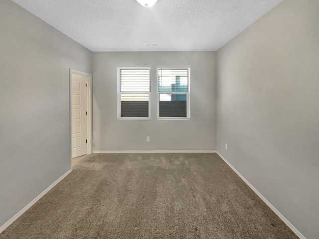 carpeted spare room with a textured ceiling