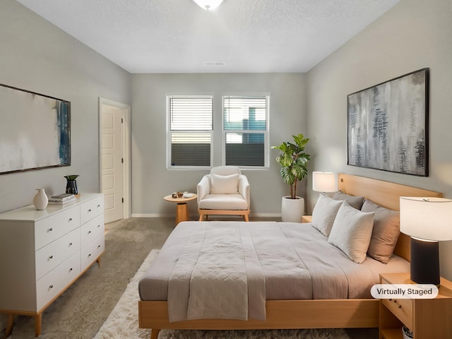 bedroom with light colored carpet and a textured ceiling