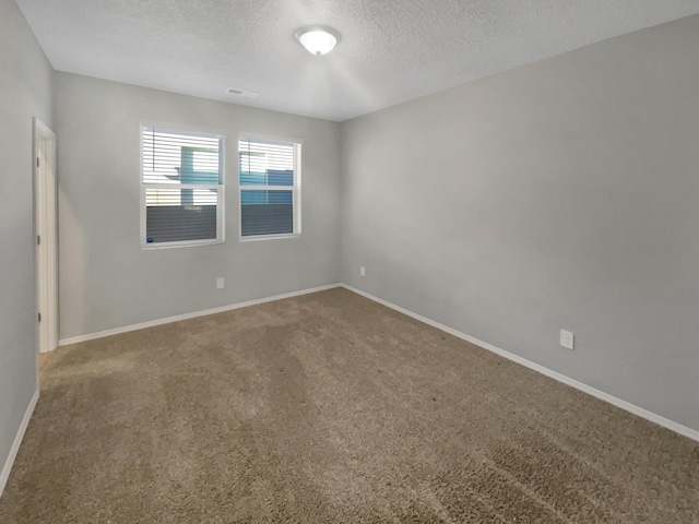 carpeted empty room with a textured ceiling