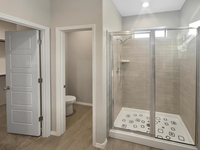 bathroom with an enclosed shower, hardwood / wood-style flooring, and toilet