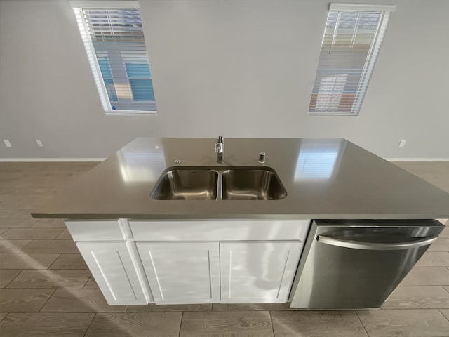 kitchen featuring tile patterned flooring, dishwasher, sink, and white cabinets