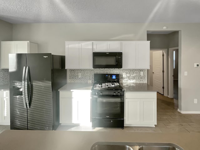 kitchen featuring white cabinetry, tasteful backsplash, black appliances, and a textured ceiling