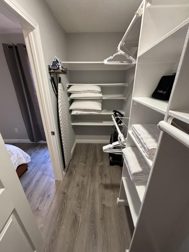 spacious closet with dark hardwood / wood-style floors