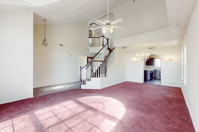 unfurnished living room featuring high vaulted ceiling, ceiling fan, and dark colored carpet