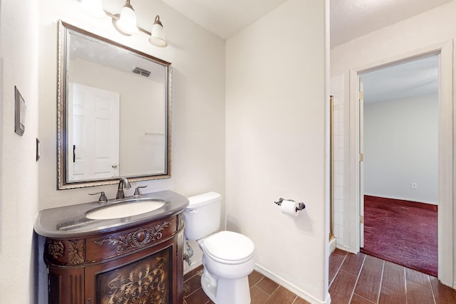 bathroom featuring vanity, walk in shower, and toilet