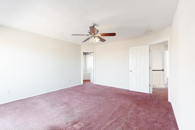 carpeted empty room featuring ceiling fan and a textured ceiling