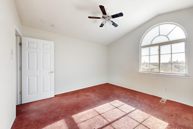 empty room featuring lofted ceiling, ceiling fan, and carpet