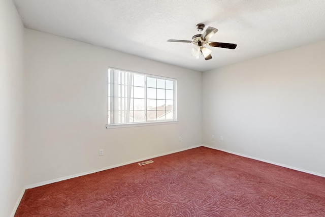 carpeted spare room with a textured ceiling and ceiling fan