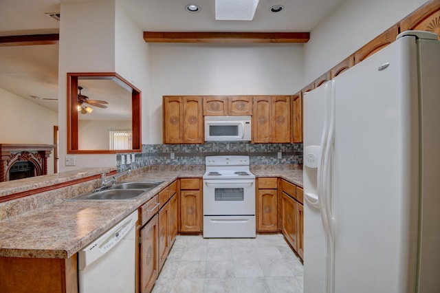 kitchen featuring ceiling fan, sink, white appliances, and kitchen peninsula