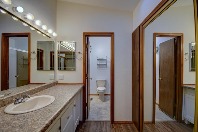 bathroom featuring vanity, hardwood / wood-style floors, toilet, and walk in shower