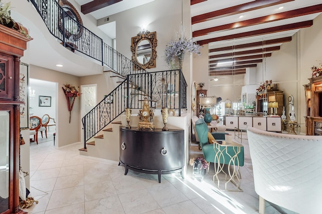 tiled entrance foyer featuring a towering ceiling and beam ceiling