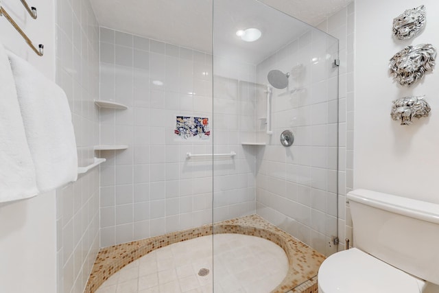 bathroom featuring toilet and tiled shower