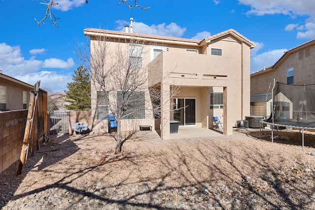 rear view of house with a patio and a trampoline