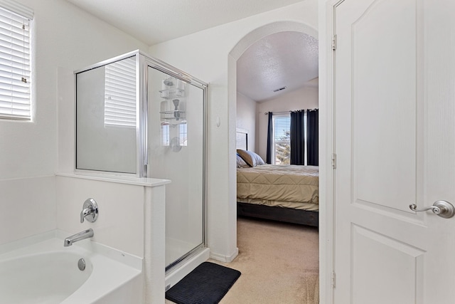 bathroom featuring independent shower and bath, lofted ceiling, and a textured ceiling