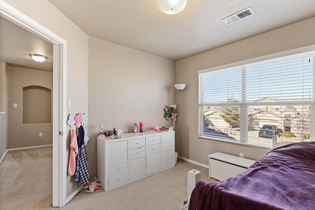 bedroom featuring light carpet and a textured ceiling