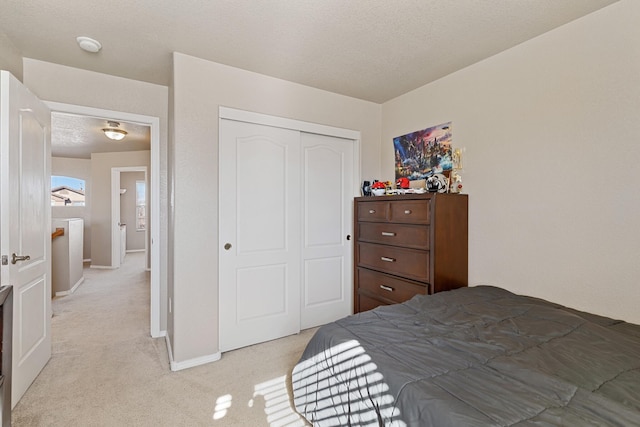 carpeted bedroom with a textured ceiling and a closet