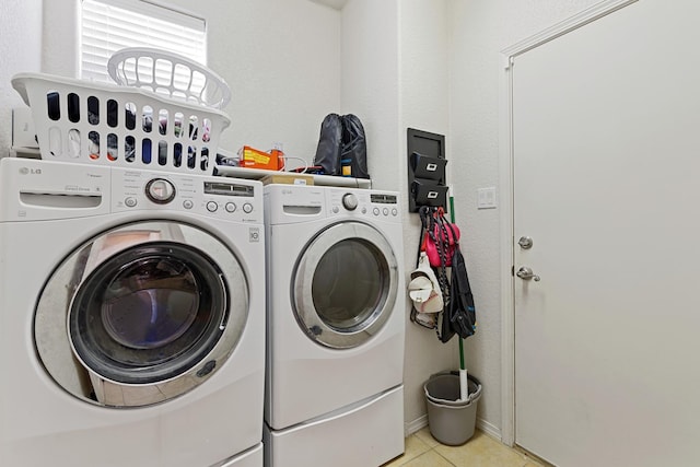 laundry area with light tile patterned flooring and washing machine and clothes dryer