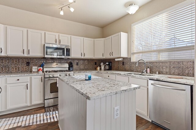 kitchen featuring a kitchen island, appliances with stainless steel finishes, tasteful backsplash, sink, and white cabinets