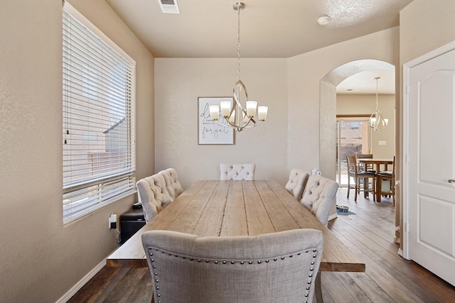 dining space featuring an inviting chandelier and dark hardwood / wood-style floors