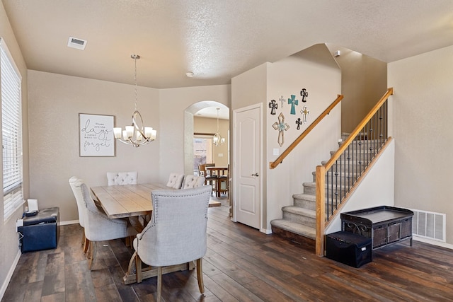 dining area featuring dark wood-type flooring, plenty of natural light, a chandelier, and a textured ceiling