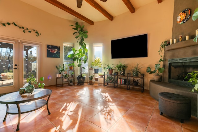 living room with light tile patterned floors, a large fireplace, beamed ceiling, and a high ceiling