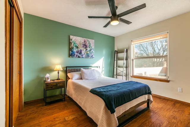 bedroom with ceiling fan, a textured ceiling, and dark hardwood / wood-style flooring