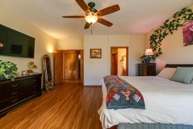 bedroom featuring ceiling fan, dark hardwood / wood-style flooring, ensuite bath, and a textured ceiling