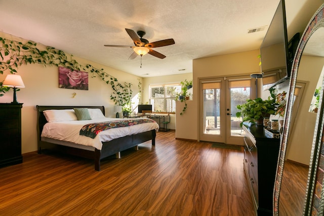 bedroom with dark wood-type flooring, ceiling fan, access to exterior, and a textured ceiling