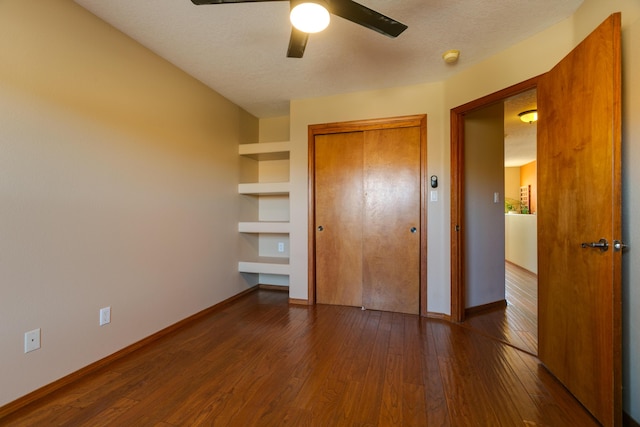 unfurnished bedroom with dark wood-type flooring, a closet, ceiling fan, and a textured ceiling