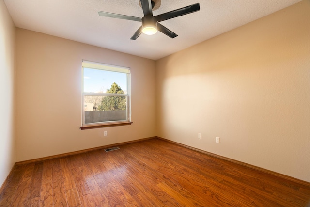 empty room with hardwood / wood-style flooring and ceiling fan