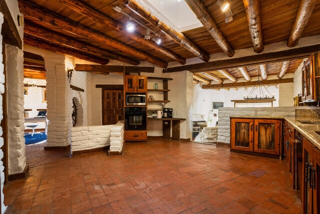 interior space with stainless steel microwave, wooden ceiling, oven, beamed ceiling, and ornate columns