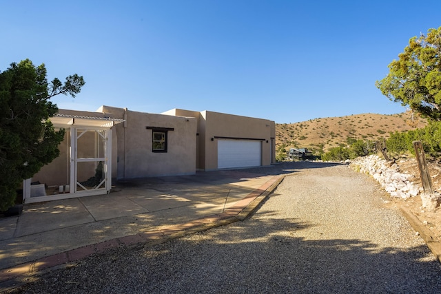 pueblo revival-style home with a garage and a mountain view