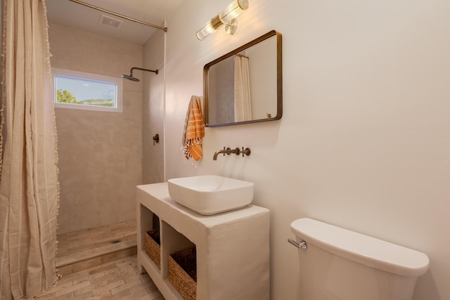 bathroom featuring walk in shower, sink, and toilet