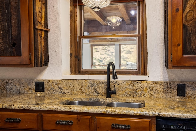 details featuring dishwasher, sink, and light stone countertops