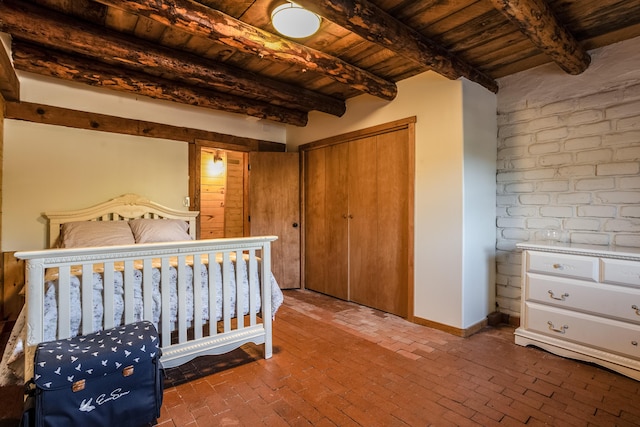 bedroom featuring wood ceiling, beam ceiling, and a closet