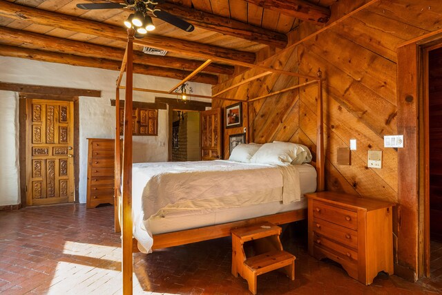 bedroom with wooden walls, wooden ceiling, and beam ceiling