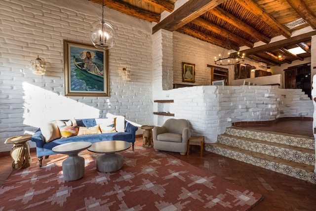 sitting room with a notable chandelier, brick wall, wooden ceiling, and beam ceiling