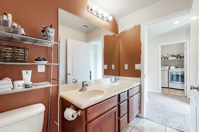 bathroom with vanity, toilet, separate washer and dryer, and tile patterned flooring