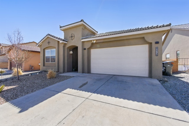 mediterranean / spanish-style house featuring stucco siding, a garage, concrete driveway, and a tile roof