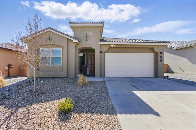 mediterranean / spanish-style home featuring stucco siding, a garage, driveway, and a tiled roof