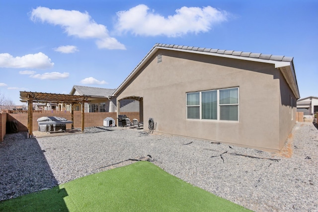 rear view of house with a patio area, stucco siding, a pergola, and a fenced backyard