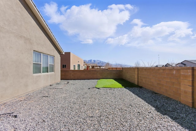 view of yard featuring a mountain view and a fenced backyard